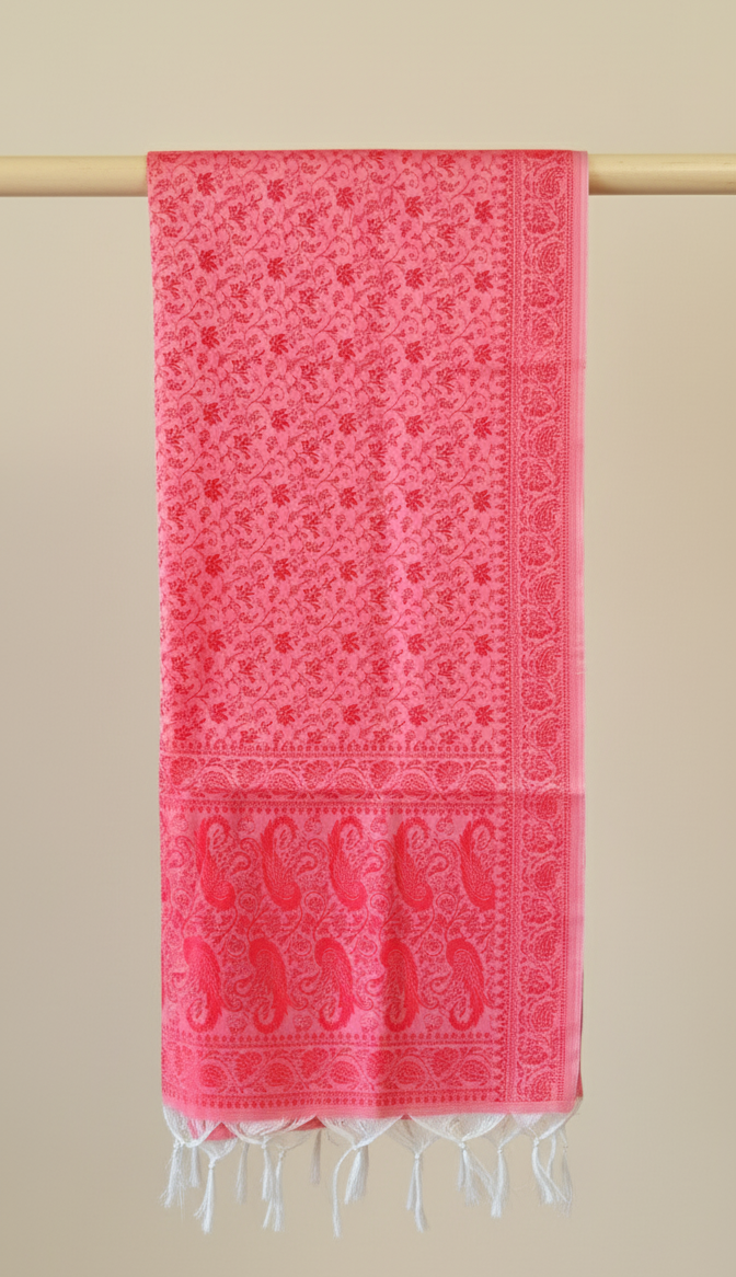Red patterned stole with white fringe on a beige background